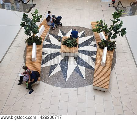 THURROCK, ESSEX - 5th August 2021: People resting on benches at Lakeside shopping centre.
