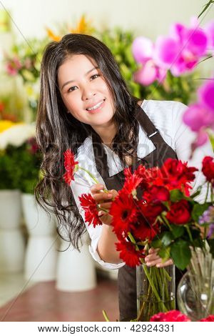 Přátelské asijské květinářství nebo prodavačka v květinářství