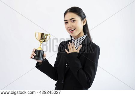 Successful Young Asian Woman Holding A Trophy On White Background. Woman With A Golden Cup Concept
