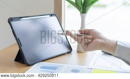 Businessman uses a tablet to examine financial data and analyze company growth graphs, Use of tablet