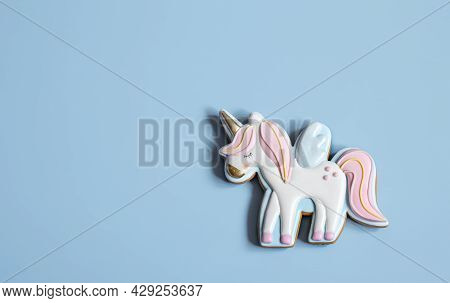 Close-up Of Colorful Gingerbread In The Shape Of A Unicorn On A Blue Background, Copy Space.