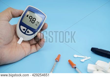 Diabetes Monitors Blood Sugar Levels, Men Use A Lancelet And A Glucometer At Home.