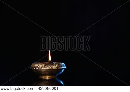 Lit Diya On Black Background, Space For Text. Diwali Lamp