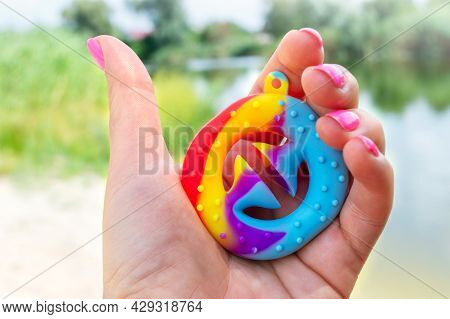 The Hand Squeezes The Snapperz, A Colorful Sensory Anti-stress Toy. Close-up.