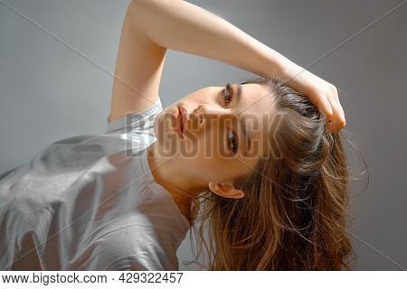 Portrait Young Woman In Studio On Graybackground. Youth Concept