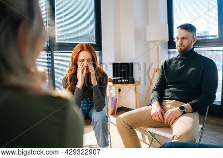 Portrait Of Sad Crying Young Woman Sharing Problem Sitting In Circle During Group Therapy Session. D