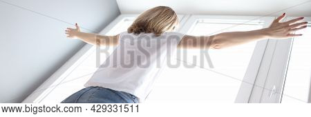 Woman Standing At The Window With Her Arms Wide Open