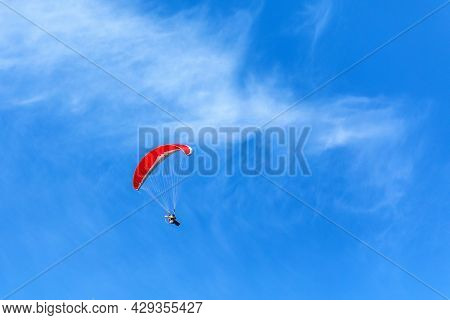Paramotor Flying In A Blue Sky. Adventure Man Active Extreme Sport Pilot Flying In Sky With Paramoto