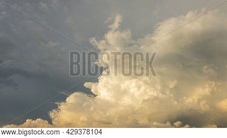 Clouds In The Blue Sky At Sunset Or Dawn Backlit By The Sun. Place For Text And Design. Heaven And C