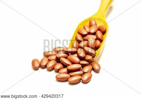 Ferrous Fumarate With Vitamins On A Wooden Spoon And On A White Background