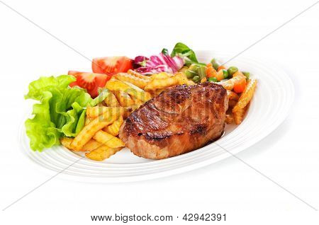 Gegrilltes Schweinesteak auf einem weiÃŸen Teller mit grÃ¼nem Salat