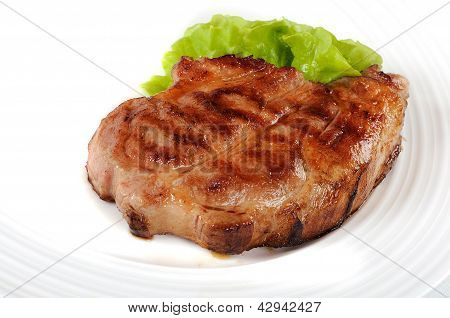 Gegrilltes Schweinesteak auf einem weiÃŸen Teller