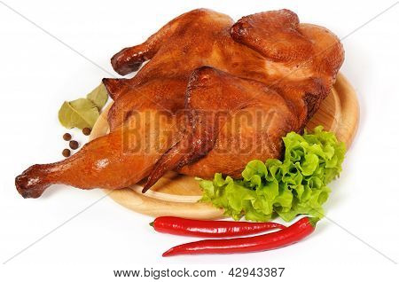 Ganzes Huhn auf der Holzplatte geräuchert