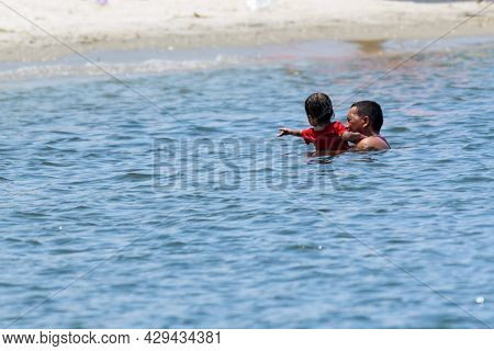 New Orleans, La - August 1: Man Swimming With Son In Lake Pontchartrain On August 1, 2021 In New Orl