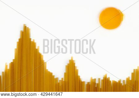 Sun In Mountains. Uncooked Spaghetti In Shape Of Hills And Egg As Sun. Travel Snack Concept. Isolate