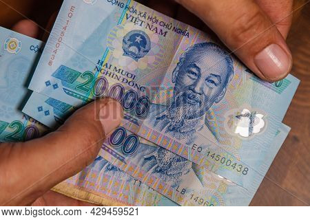Male Hand Holds A Fan Of  Vietnames Dong Banknote, The Currency Of Vietnam.  Close Up Polymer Money 