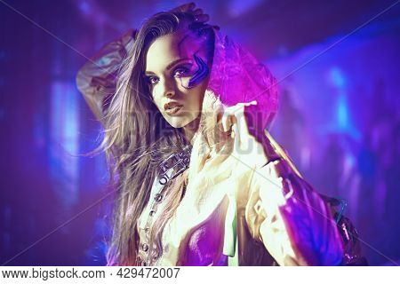 Virtual reality, city of the future. Beautiful cyber girl in hi-tech clothes of the future stands in the neon light of the night cyber city.