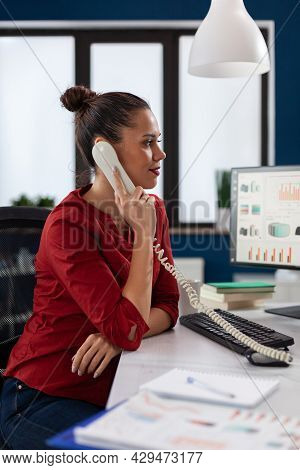 Businesswoman Sitting At Desk In Corporate Office Discussing With Client About Important Project, Du