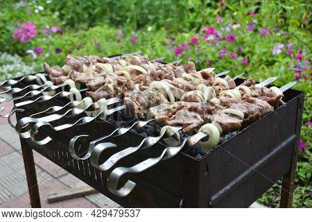 A Close-up Of Shashlik Or Shish Kebab, Marinated Chunks Of Meat On Skewers Cooked On Mangal Outdoors