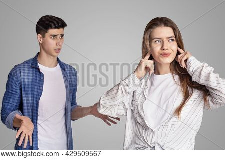 Quarrel And Showdown. Sad Woman Covers Her Ears With Fingers, Upset Man Expresses Negative Emotions