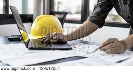 Architect Engineers Are Using Laptops To Check House Plans And Print Them Out On Paper After Designi