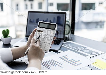 A Woman Pressing A White Calculator With Her Hand, A Female Financial Businesswoman Keeping Accounti