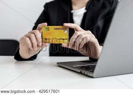 A Business Woman Holds A Credit Card To Make Payments On The Website Where She Is Shopping Online. C