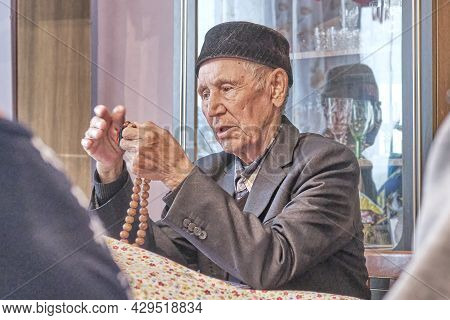 Asian Senior Muslim Man, Mullah Talking Counting Rosary At Rural House.