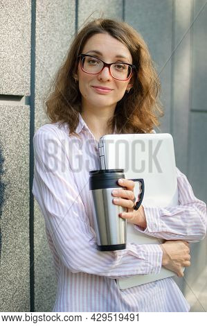 Female Portrait Of Young Woman With Silver Laptop And Cup Of Coffee Waiting For A Meeting Near Dark 
