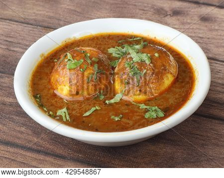 Anda Masala Or Egg Curry Is Popular Indian Spicy Food, Served In A Ceramic Bowl Over Rustic Wooden B