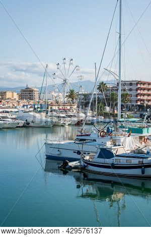 Gandia, Spain - 26 July 2021: Boats In The Port With View On The City Coastline With Ferris Wheel In