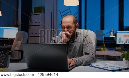 Exhausted Sleppy Businessman Yawning While Working At Management Project Deadline Late At Night In S