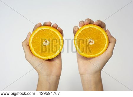 Close Up Of Hands Holding Sunkist Orange Slices, Isolated White Background
