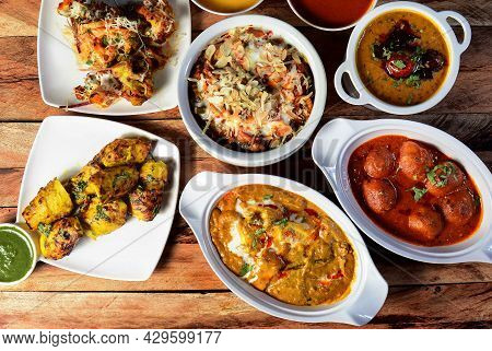 Assorted Indian Food On Wooden Background. Dishes And Appetizers Of Indian Cuisine