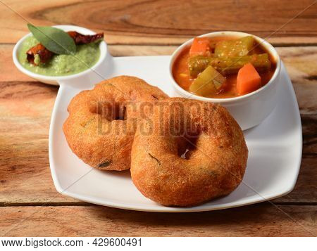 Indian Fried Snack Medu Vada With Sambar And Coconut Chutney In Plate On Rustic Wooden Background, S