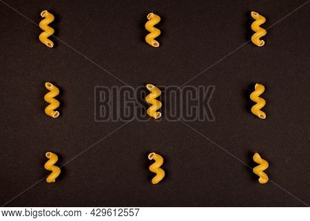 Italian Spiral Pasta On Black Background. Bunch Of Helical Amori. Uncooked Cavatappi.