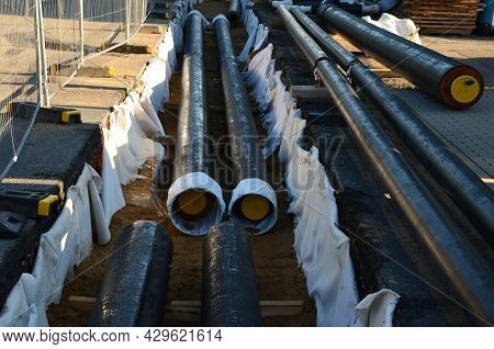 Installation Of Hot Water Pipes For Heating Apartments. Insulated Pipes Are Laid In The Road For San
