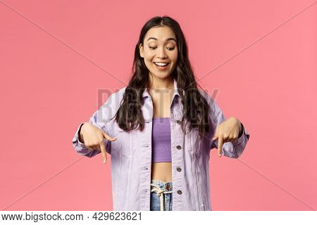 Portrait Of Curious Good-looking, Stylish Female In Denim Jacket Over Crop-top, Smiling Excited And 