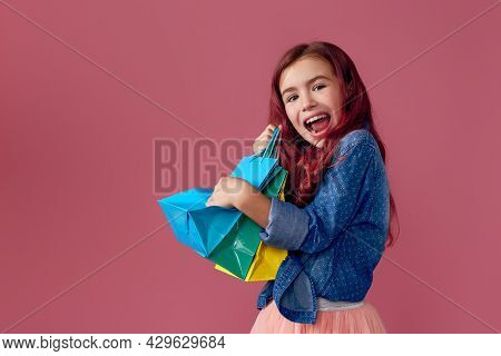 Little Caucasian Child Girl Holds Shopping Bags