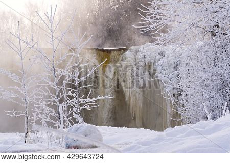 Frozen Beautiful Waterfall Jagala Under The Sunrise Lights In Winter, Reflection In River. Estonia.