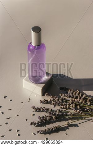 Lavender Flowers And Hydrolat In Glass Bottle On Light Grey Background, Top View. Aromatherapy Conce