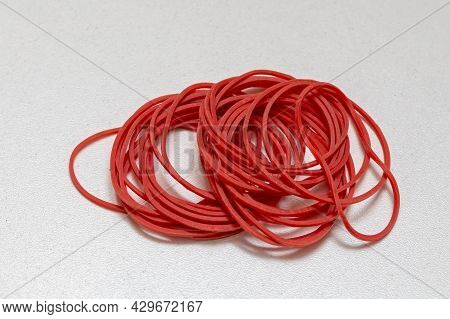 Small Pile Of Red Rubber Bands Elastic At Table