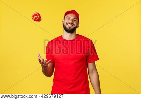 Online Delivery, Shopping And Food Order Concept. Carefree Smiling Courier In Red Uniform Cap And T-