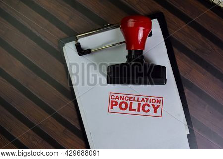 Red Handle Rubber Stamper And Cancellation Policy Text Isolated On Wooden Table.