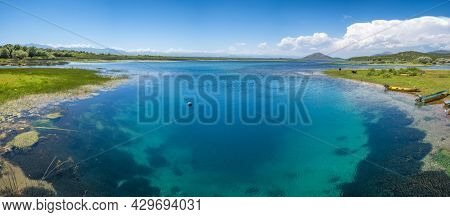 Crystal clear blue water of Skadar lake located at the border of Albania and Montenegro. Panorama of deep turquoise Skadar lake at sunny day