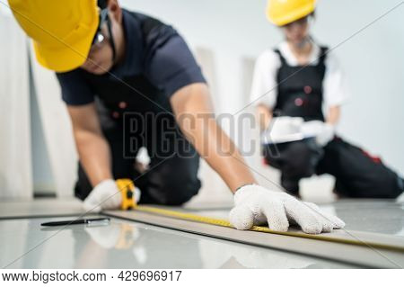 Asian Craftsman Worker People Installs Laminate Board On Floor At Home. Attractive Joiner And Carpen