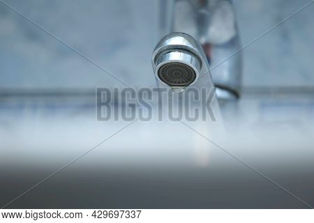 Dripping Old Faucet In Bathroom. Water Dripping From A Tap Into White Sink, Close-up Bottomview. Rec