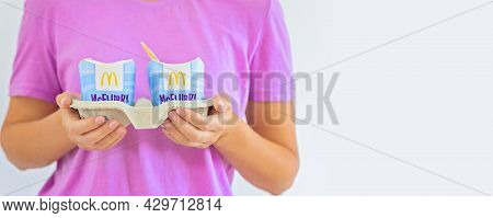 Woman In A Purple T-short Holding An Ice Cream Mcflurry. Delivery Mccafe. Fast Food Restaurant Mcdon