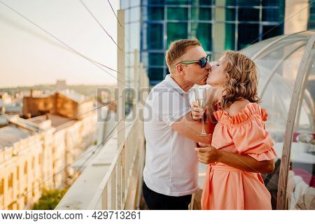 Man And Woman Drink Champagne On Bruderschaft In A Rooftop Cafe.