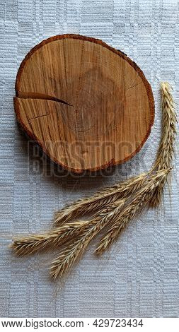 Composition Of A Wooden Cut And Rye Ears On A Self-woven Tablecloth